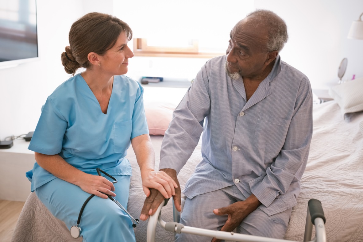 A nurse talking to a patient Description automatically generated