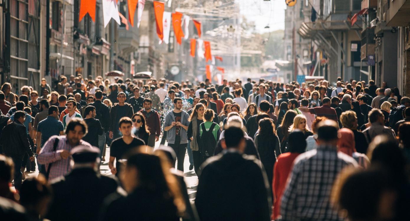 A crowd of people walking on a street Description automatically generated