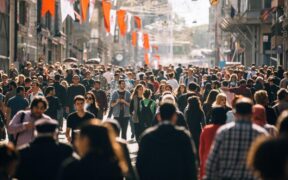 A crowd of people walking on a street Description automatically generated